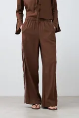 Pantalón de lino color chocolate, de corte palazzo, con cintura elastizada y vivo blanco en los laterales.