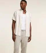 Pantalón relaxed de hombre confeccionado en tejido oxford de algodón color beige, con trabillas en la cintura y cordón para lazo.