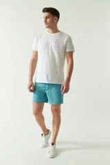 Short de baño celeste con estampado de hojas, cintura elástica con cordón ajustable, dos bolsillos laterales y uno trasero.