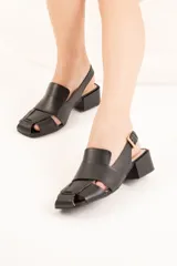 Sandalia de cuero trenzado color negro, con punta cuadrada, talón abierto y pulsera ajustable con hebilla metálica. Tiene taco ancho forrado en cuero de 4 cm de altura.