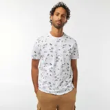 Remera blanca de manga corta con estampado de palmeras y paisajes en azul.