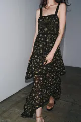 Vestido negro con estampado floral, escote recto y tirantes finos. Detalle de aplicación de hilo metalizado, lentejuelas y puntilla combinadas a tono. Bajo asimétrico.