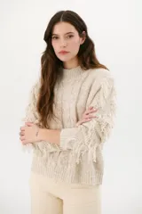 Sweater color arena de tejido de punto con cuello redondo y mangas largas con flecos.
