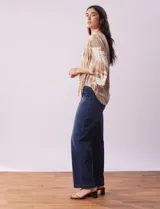 Blusa de crepe color beige con estampado de hojas blancas, cuello redondo con escote en V y lazo de ajuste, mangas 3/4 con tajo.