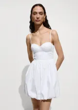 Vestido corto blanco con escote corazón y tirantes finos. Falda con volumen y forro interior.