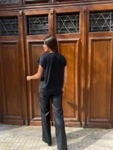 Blusa de lurex color negro con tajo en la parte delantera y mangas cortas.