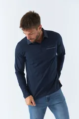 Polo de manga larga negra con cuello clásico, tapeta de dos botones y bolsillo de parche en el pecho con ribete blanco. Logo de la marca bordado en blanco sobre el bolsillo.