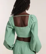 Blusa cropped de sastrería color verde agua, con escote cuadrado, mangas largas abullonadas y botones matizados.