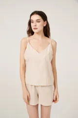 Conjunto de pijama de satén a rayas verticales color beige, compuesto por un top con breteles finos y escote en V, y un short de calce holgado.