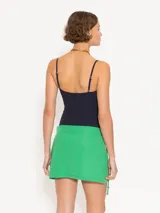 Minifalda verde con diseño cruzado y lazo lateral.