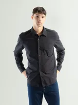 Camisa de manga larga confeccionada en algodón color negro, de corte clásico, con cuello americano, cierre frontal con botones y bolsillo en el lado izquierdo del pecho.