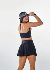Conjunto deportivo negro compuesto por top con breteles finos y falda corta con volados.