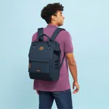 Mochila Cabaia modelo Adventurer Reykjavik, color azul con detalles en marrón. Tiene sistema MOLLE, compartimento acolchado para tablet o PC, correa para sujetar a la maleta y tirantes acolchados antitranspirantes. Vegana e impermeable.
