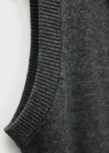 Chaleco sin mangas de punto gris, con cuello polo y botones frontales.