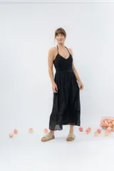 Vestido largo negro con top tejido en crochet y falda de gasa liviana con caída natural. Escote halter con breteles que atan al cuello y detalle de puntilla en la unión del busto.