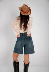 Bermuda de jean azul claro, corte a la rodilla, con bolsillos delanteros y traseros.