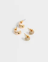 Set de dos pares de aros dorados. Un par con forma de gota con strass y otro par con forma de gota lisa.