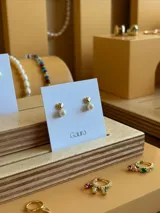 Aros colgantes con perlas y base dorada en forma de corazón.