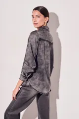 Camisa de denim de corte al cuerpo, con dos bolsillos frontales y cierre de botones.