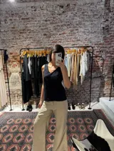 Musculosa negra con bordado floral, escote en V y breteles finos.