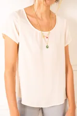 Blusa color crema de poliéster, con cuello redondo y mangas cortas.