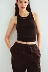 Pantalón marrón de algodón, corte holgado, tiro alto, cintura elástica fruncida con cordón ajustable, piernas anchas y bolsillos laterales.