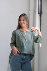Blusa verde militar de corte holgado, con escote en V, mangas 3/4 y detalle de bordado calado con forma de paisley en el frente.