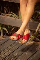 Sandalias rojas con base de corcho y hebilla dorada con el logo de la marca.