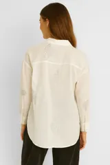 Camisa color crudo de viscosa con bordado de conchas marinas en gris, corte holgado, cuello camisero y cierre frontal con botones.