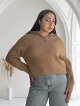 Sweater beige de tejido de punto con cuello polo y cierre de cremallera metálica.