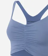 Top deportivo celeste con escote nadador en la espalda y fruncido delantero.