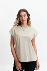 Musculosa oversize color beige con estampado dorado que dice "If you never try you will never know".