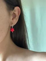 Aros colgantes con forma de estrella roja y aro de acero quirúrgico dorado.