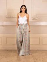 Pantalón palazzo de tiro alto con estampado geométrico multicolor y cintura elastizada con cordón ajustable y borlas decorativas.