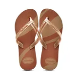 Ojotas Havaianas color marrón con diseño de rayas diagonales en tono beige y tiras finas color oro rosa.
