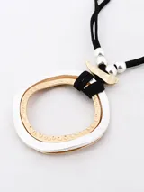 Collar con cordón negro y dije circular doble, uno plateado con textura martillada y otro dorado con textura de pequeñas esferas.