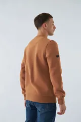 Buzo marrón de felpa con cuello redondo, mangas largas y puños. Estampado frontal con la frase "break the limits" y logo de la marca Mistral.