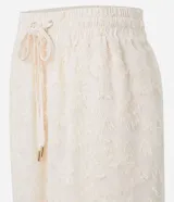 Pantalón recto de chiffon color crema con cintura elástica, lazo ajustable y textura de encaje.