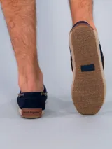 Mocasines náuticos de cuero azul marino con cordones marrones, ojales metálicos y suela de yute.