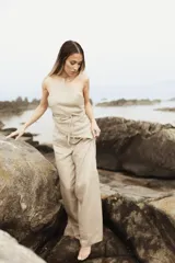 Pantalón de lino color beige, de calce amplio y tiro alto. Presenta abertura lateral en el ruedo.