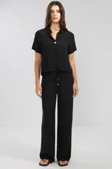 Pantalón negro de crepe con cintura elastizada, corte recto y bolsillos laterales.