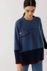 Sweater azul de lana con diseño de bloques de color, bolsillo en el pecho y costuras decorativas en color borgoña.