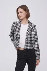 Blazer corto con estampado a cuadros blancos y negros, solapas y cierre con dos botones.