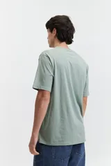 Remera color salmón de corte clásico, cuello redondo y logo bordado en el pecho.