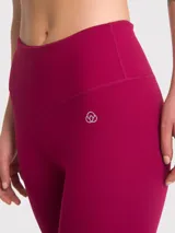 Calza deportiva larga color borgoña, de tiro alto y calce ajustado.