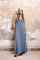 Vestido largo de lino color celeste, con tirantes finos ajustables en la espalda y corte en la cintura.