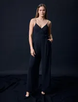 Enterito celeste de crepe marca Luxology, con escote en V cruzado, cintura elastizada, espalda en punto smock y tirantes con detalle de cadenas.