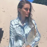 Campera plateada de cuero ovino, con cuello clásico, cierre frontal con botones a presión, bolsillos con solapa en el pecho y corte entallado.