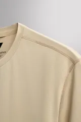 Camiseta deportiva de entrenamiento, corte regular fit, color gris claro, con cuello redondo y manga corta. Confeccionada en tejido técnico ligero y elástico con estructura Quick Dry nivel 2. Presenta costuras planas y un pequeño logo estampado en la parte inferior derecha.