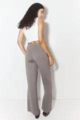 Pantalón gris de punto suave, tiro alto, corte amplio y cintura elástica.
